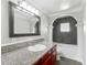 Bathroom vanity features a granite counter, dark wood cabinets, and large framed mirror at 3702 W Reynolds St, Plant City, FL 33563
