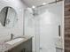 Updated bathroom featuring modern fixtures, a gray vanity, a stylish round mirror, and a glass-enclosed shower at 3702 W Reynolds St, Plant City, FL 33563