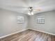 Spacious bedroom featuring wood-look floors, two windows, and a ceiling fan at 3702 W Reynolds St, Plant City, FL 33563