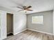 Cozy bedroom with wood-look flooring, ceiling fan, and a closet for ample storage at 3702 W Reynolds St, Plant City, FL 33563