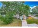 Front exterior featuring a cozy home with a stone chimney, well-maintained lawn and driveway at 3702 W Reynolds St, Plant City, FL 33563