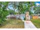 Charming single-Gathering home featuring a stone chimney and a driveway, nestled under large trees at 3702 W Reynolds St, Plant City, FL 33563