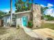 Cozy home with a blue front door and a stone chimney, nestled on a well-maintained lot at 3702 W Reynolds St, Plant City, FL 33563