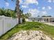 Large backyard with healthy grass, mature shade trees, white privacy fence, and access to patio at 4501 Huntington Ne St, St Petersburg, FL 33703