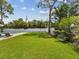Spacious backyard featuring lush lawn, privacy fence, mature trees, and a glimpse of the inviting pool at 4501 Huntington Ne St, St Petersburg, FL 33703