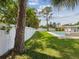 Well-maintained backyard with lush lawn, mature trees, inviting pool, and white privacy fence at 4501 Huntington Ne St, St Petersburg, FL 33703
