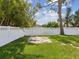 Lush backyard with a large green lawn, mature shade tree, and white privacy fence at 4501 Huntington Ne St, St Petersburg, FL 33703