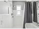 Bathroom showcasing a white-tiled shower area and modern showerhead and grey shower curtain at 4501 Huntington Ne St, St Petersburg, FL 33703