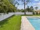 Inviting backyard pool with a well-maintained lawn and a secure white fence at 4501 Huntington Ne St, St Petersburg, FL 33703