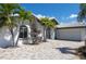 Charming single-story home featuring a white exterior, gray tile roof, and well-maintained landscaping at 511 64Th Ave, St Pete Beach, FL 33706