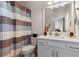Bright bathroom featuring a vanity, mirror, toilet, and shower with a decorative curtain at 6011 Caldera Ridge Dr, Lithia, FL 33547