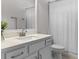 Well-lit bathroom showcasing a sleek vanity with quartz countertop, modern fixtures, and a shower with a curtain at 6011 Caldera Ridge Dr, Lithia, FL 33547