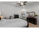 Bright bedroom with modern touches, featuring dark furniture, a bed, and a glimpse into an attached bathroom at 6011 Caldera Ridge Dr, Lithia, FL 33547
