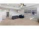 Spacious bonus room with plenty of windows, featuring a sectional sofa and carpeted floors at 6011 Caldera Ridge Dr, Lithia, FL 33547
