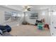 Spacious bonus room with lots of windows and natural light, perfect for Gathering fun, featuring a tv and play area at 6011 Caldera Ridge Dr, Lithia, FL 33547