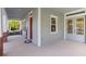 Spacious front porch featuring neutral tones, decorative brick pillars, and access to both the front door and side entrance at 6011 Caldera Ridge Dr, Lithia, FL 33547