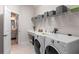 Practical laundry room with counter space, washer, dryer, shelving, and stylish tile floors at 6011 Caldera Ridge Dr, Lithia, FL 33547