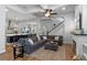 Open-concept living room and kitchen featuring hardwood floors, a large gray couch, and barstool seating at 6011 Caldera Ridge Dr, Lithia, FL 33547