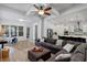 Bright, open-concept living space with hardwood floors, gray couch, kitchen, and ceiling fan at 6011 Caldera Ridge Dr, Lithia, FL 33547