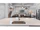 Open concept living space with a kitchen island, a fireplace, and a staircase creating a warm and inviting atmosphere at 6011 Caldera Ridge Dr, Lithia, FL 33547