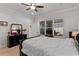 Bright main bedroom featuring a ceiling fan, large window, and dark wood furniture with a plush, white comforter at 6011 Caldera Ridge Dr, Lithia, FL 33547