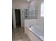 Luxurious bathroom featuring a glass shower and a soaking tub with tile surround at 603 5Th S St, Safety Harbor, FL 34695