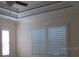 Main bedroom features a tray ceiling, fan, and windows with plantation shutters at 603 5Th S St, Safety Harbor, FL 34695