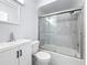 Clean, white bathroom featuring a shower-tub combination with glass doors and updated fixtures at 6609 Dartmouth N Ave, St Petersburg, FL 33710