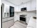 Modern kitchen featuring stainless steel appliances and sleek white cabinetry at 6609 Dartmouth N Ave, St Petersburg, FL 33710