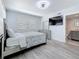 Bright main bedroom with a ceiling fan, large TV, and ensuite bathroom entrance at 6609 Dartmouth N Ave, St Petersburg, FL 33710