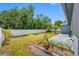 Spacious backyard features a white fence, lush lawn, garden bed, and potential for outdoor activities at 7080 Nicole Ln, Largo, FL 33771