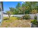 Backyard area enclosed by a white vinyl fence and lots of green foliage at 7080 Nicole Ln, Largo, FL 33771
