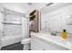 Bathroom with tub and shower, marble-look wall tile and white vanity at 7080 Nicole Ln, Largo, FL 33771