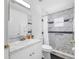 Bathroom features a modern vanity, toilet, and a walk-in shower with elegant marble tiling at 7080 Nicole Ln, Largo, FL 33771