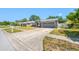 Charming single-story home with a gray exterior, two-car garage, and a long driveway. American flag on display at 7080 Nicole Ln, Largo, FL 33771