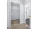 Hallway view of a walk-in closet and tiled shower with a frameless glass door at 7080 Nicole Ln, Largo, FL 33771