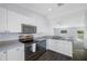Well-lit kitchen featuring stainless steel appliances, white cabinets, and modern countertops at 7080 Nicole Ln, Largo, FL 33771