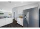 Kitchen featuring white cabinets, stainless steel refrigerator, and dark floors at 7080 Nicole Ln, Largo, FL 33771