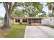 Charming single-story home featuring a large tree and screened front porch at 7141 56Th N St, Pinellas Park, FL 33781