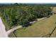 Aerial view of land featuring trees, a dirt road, a grassy field, and a fenced in area at 7509 Hackamore Rd, Zephyrhills, FL 33541