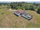 Aerial view of the screened pool, large backyard and adjacent structure with a white exterior on the property at 7509 Hackamore Rd, Zephyrhills, FL 33541