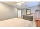 Bright bedroom features an ensuite, ceiling fan, desk and light wood flooring at 7509 Hackamore Rd, Zephyrhills, FL 33541