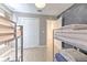 Bedroom featuring bunk beds, wood-look flooring, access to a closet and view of the hallway at 7509 Hackamore Rd, Zephyrhills, FL 33541