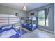 Bright bedroom with bunk beds, light wood flooring, and a window letting in natural light at 7509 Hackamore Rd, Zephyrhills, FL 33541