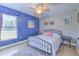 Comfortable bedroom with a ceiling fan, light wood floors, and bright blue accent wall at 7509 Hackamore Rd, Zephyrhills, FL 33541