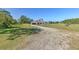 View of the front exterior of the home with its large lawn and long driveway at 7509 Hackamore Rd, Zephyrhills, FL 33541