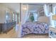 Well-lit main bedroom featuring a canopy bed, closet, and hardwood floors at 7509 Hackamore Rd, Zephyrhills, FL 33541