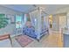 Bright main bedroom with a four-poster bed, hardwood floors, and contemporary finishes at 7509 Hackamore Rd, Zephyrhills, FL 33541