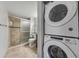 Modern bathroom featuring a tiled shower and convenient stacked washer and dryer at 7520 Sunshine Skyway S Ln # 110, St Petersburg, FL 33711