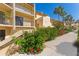 Charming condo exterior featuring well-maintained landscaping and private balconies on a sunny day at 7520 Sunshine Skyway S Ln # 110, St Petersburg, FL 33711